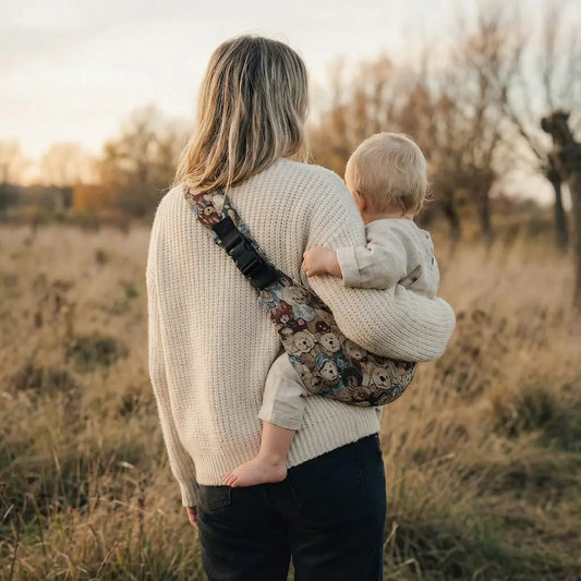 Needella CozyCarry Hüfttrage mir Teddymotiv, Mutter trägt ihr Baby nah am Körper im Alltag